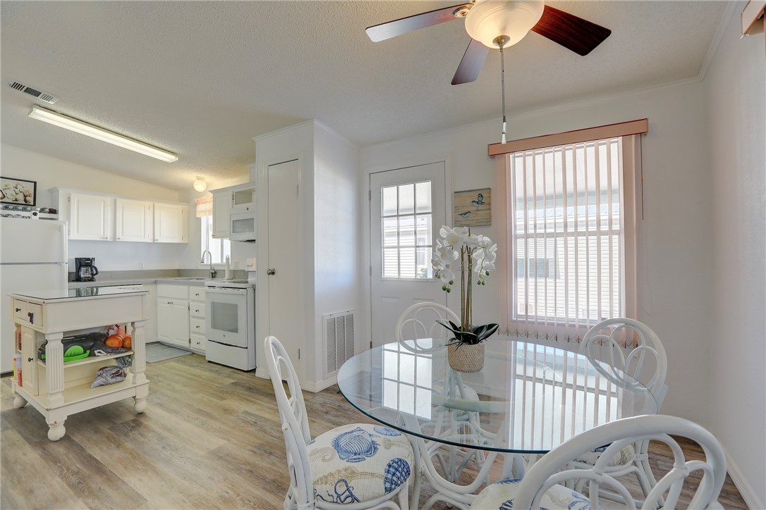 7576 Chasta Road Micco, FL 32976 - Photo 5 of 27 a open dining room with wooden floor a chandelier a wooden table and chairs