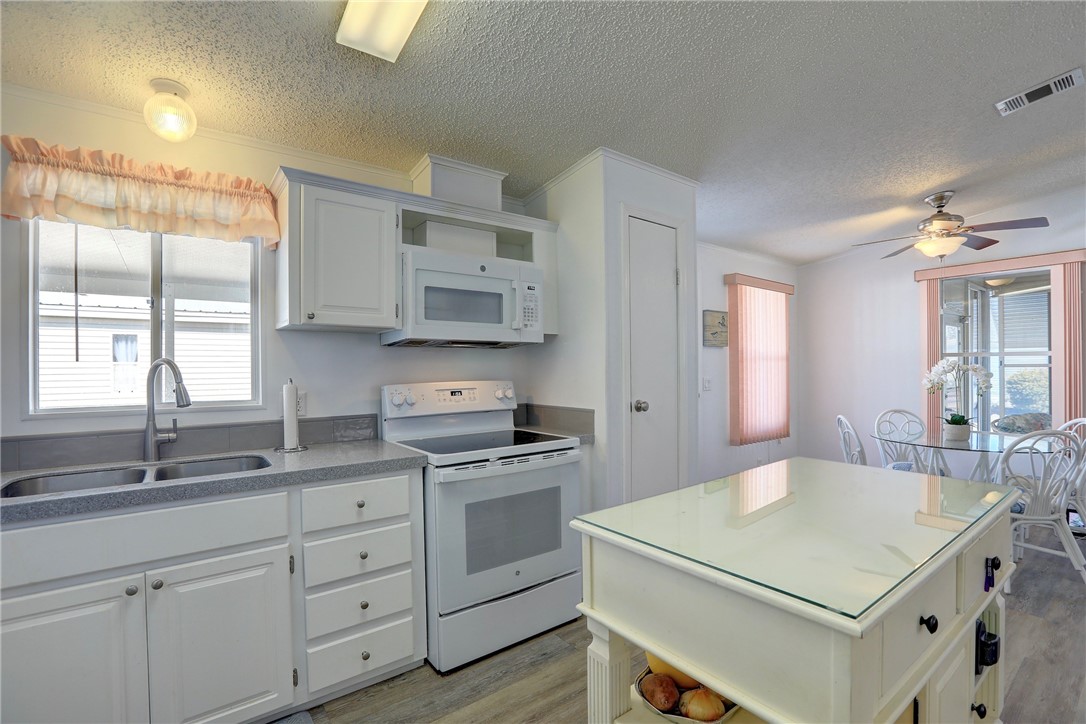 7576 Chasta Road Micco, FL 32976 - Photo 8 of 27 a kitchen with a stove a sink and a refrigerator
