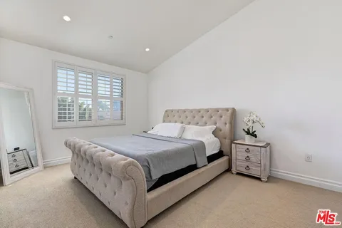 a bedroom with a bed lamp and a window
