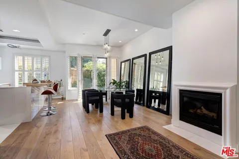 a living room with furniture large window and wooden floor