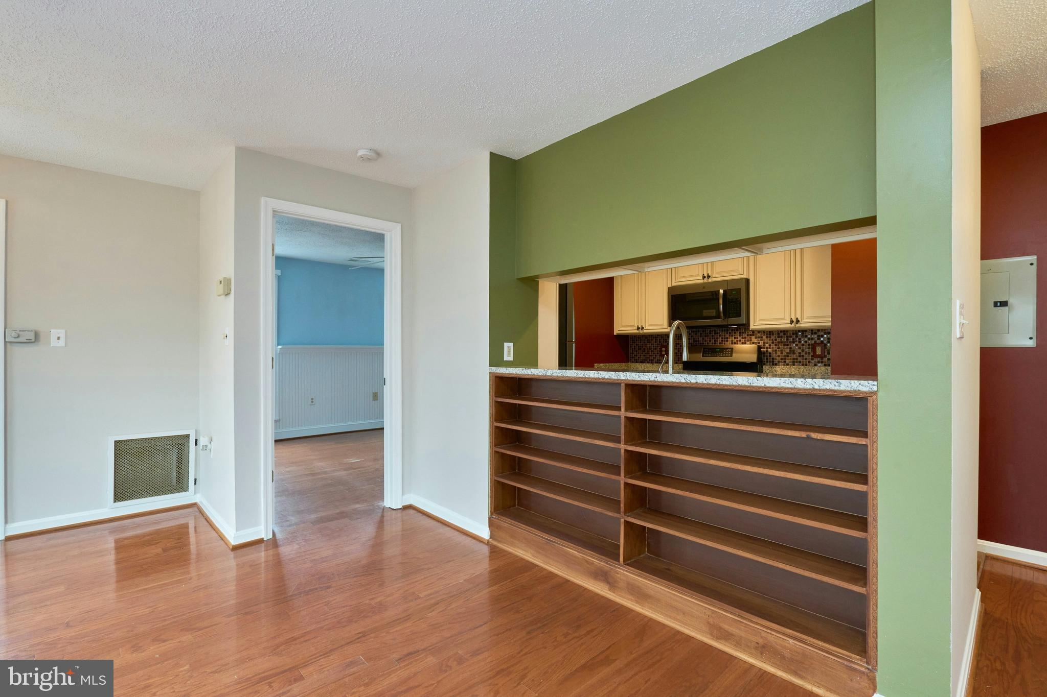 21014 Timber Ridge Terrace, Unit 302 Ashburn, VA 20147 - Photo 13 of 32 a view of an empty room with wooden floor and a window