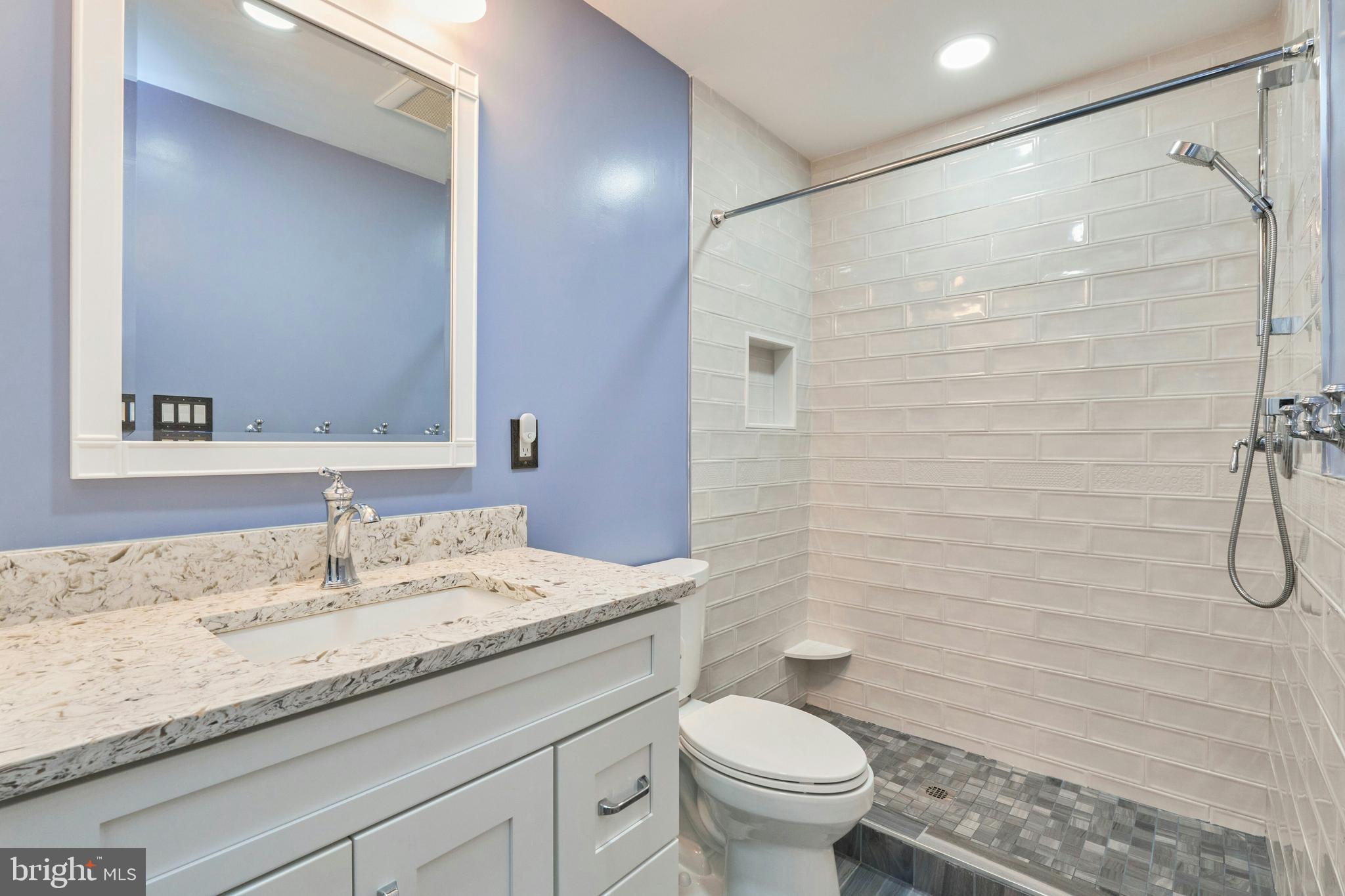 21014 Timber Ridge Terrace, Unit 302 Ashburn, VA 20147 - Photo 16 of 32 a bathroom with a granite countertop sink a toilet and a mirror