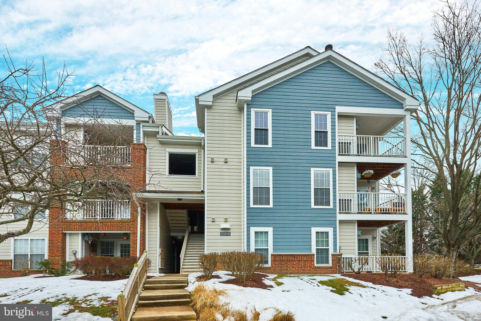 21014 Timber Ridge Terrace, Unit 302 Ashburn, VA 20147 - Photo 2 of 32 a front view of a house with a yard