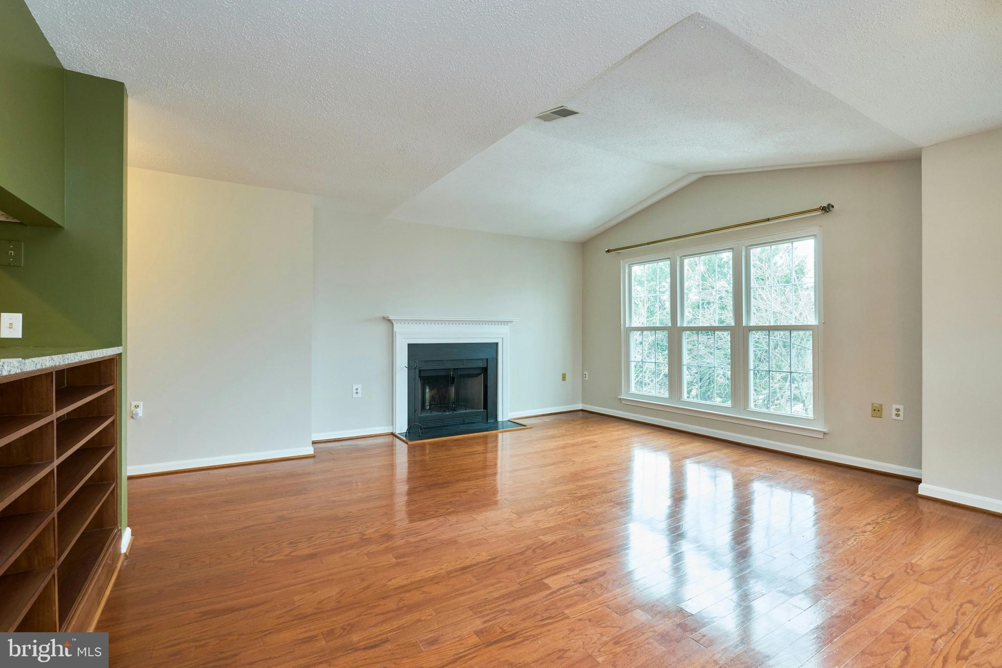 21014 Timber Ridge Terrace, Unit 302 Ashburn, VA 20147 - Photo 21 of 32 a view of empty room with wooden floor and fireplace