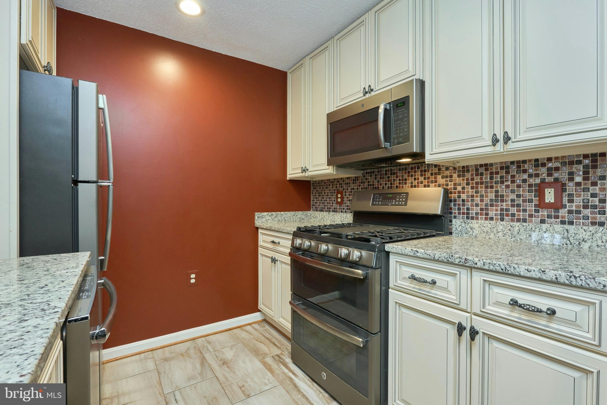 21014 Timber Ridge Terrace, Unit 302 Ashburn, VA 20147 - Photo 23 of 32 a kitchen with granite countertop cabinets stainless steel appliances and wooden floor