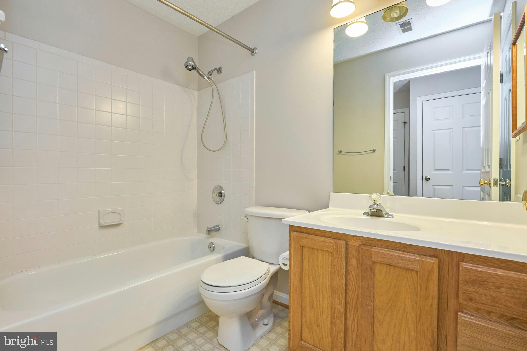 21014 Timber Ridge Terrace, Unit 302 Ashburn, VA 20147 - Photo 29 of 32 a bathroom with a sink a toilet and shower