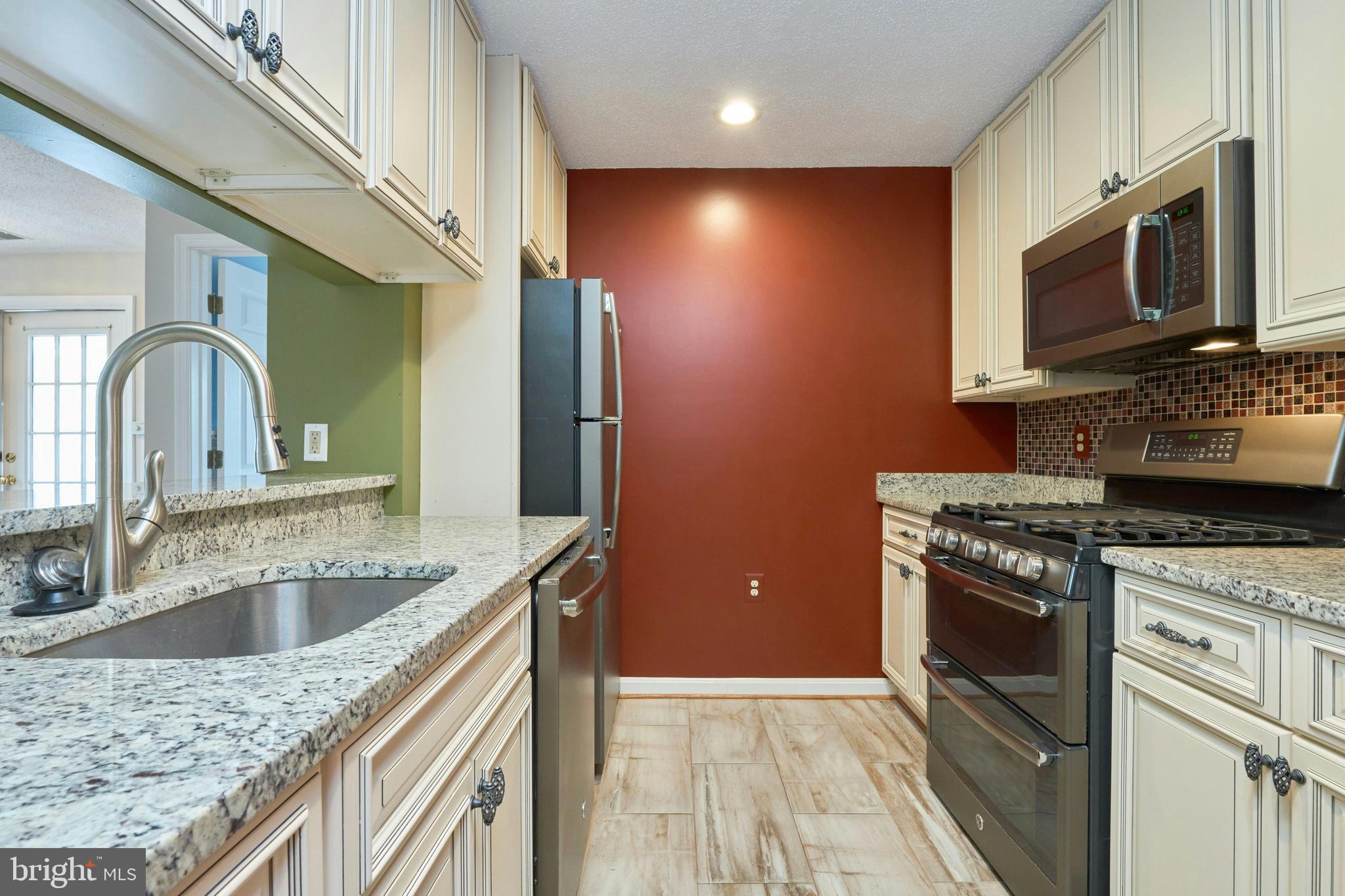 21014 Timber Ridge Terrace, Unit 302 Ashburn, VA 20147 - Photo 3 of 32 a kitchen with stainless steel appliances granite countertop a sink stove and microwave