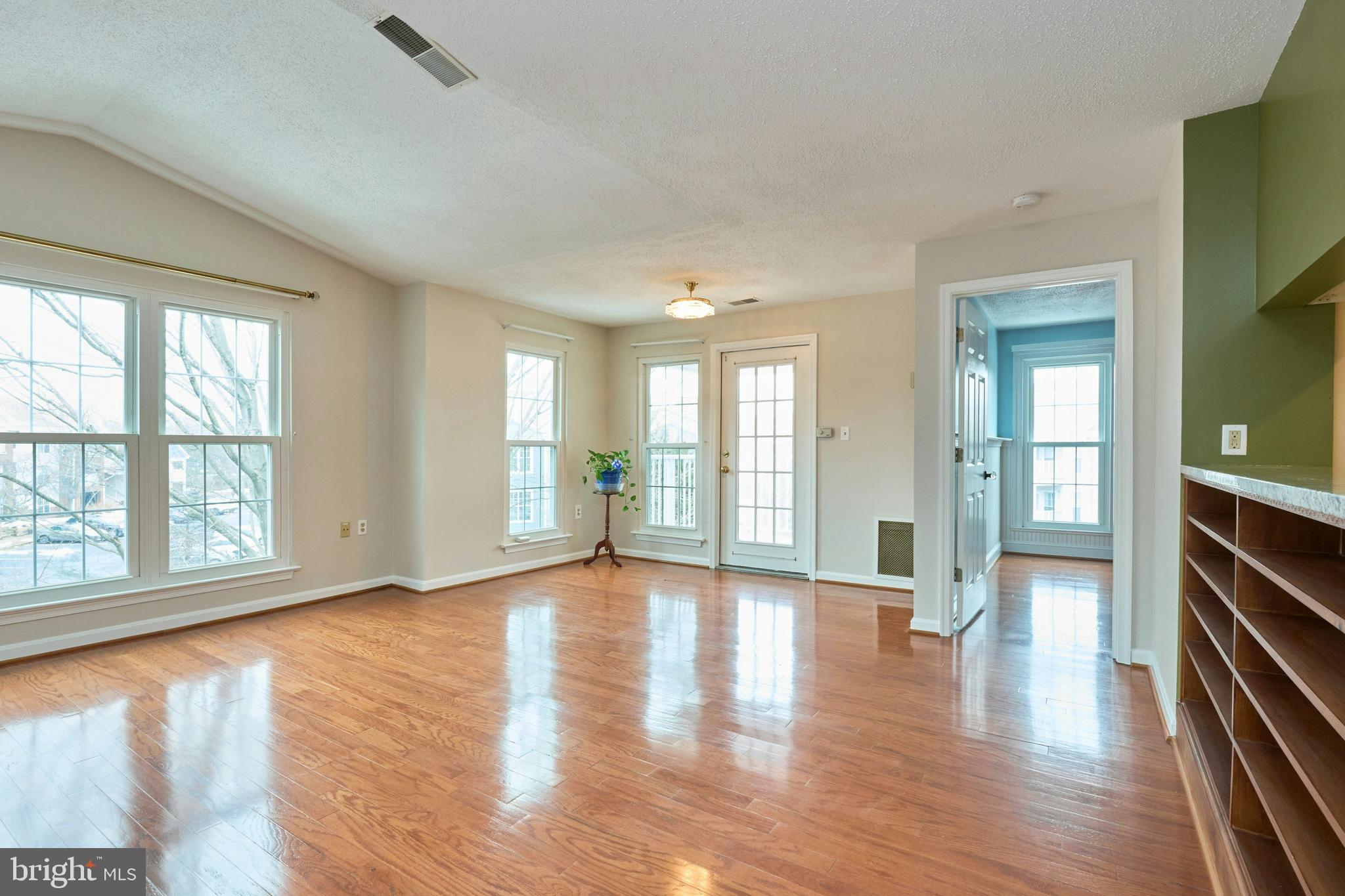21014 Timber Ridge Terrace, Unit 302 Ashburn, VA 20147 - Photo 6 of 32 an empty room with wooden floor and windows