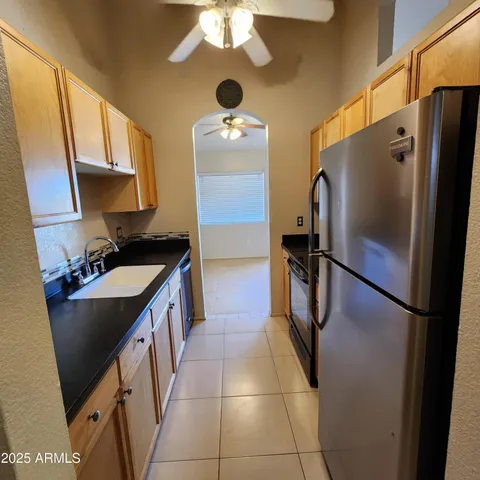 a kitchen with stainless steel appliances granite countertop a refrigerator a stove a sink and dishwasher
