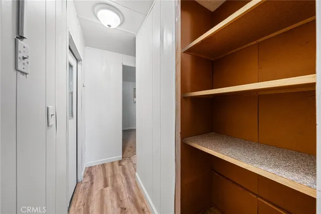 a view of an empty room with cabinet and closet area