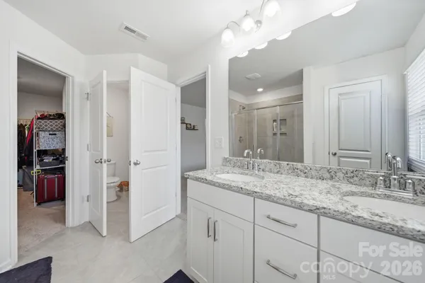 a bathroom with a granite countertop double vanity sink and a mirror