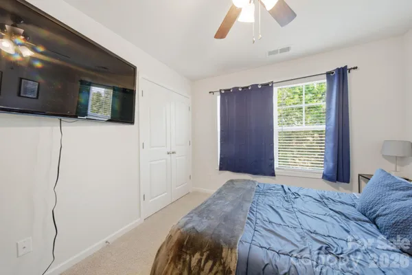 a bedroom with a large bed and a flat tv screen