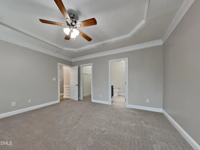 a view of an empty room and chandelier fan
