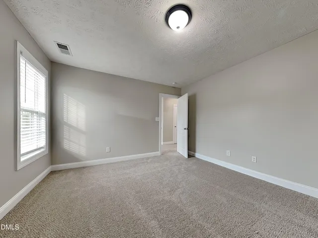 a view of an empty room and closet area