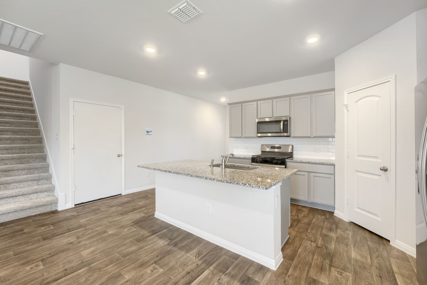 13507 Howser Trace Manor, TX 78653 - Photo 7 of 28 A contemporary kitchen featuring an inviting island with a sink and ample counter space.