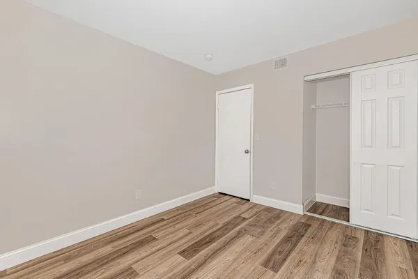 a view of an empty room with wooden floor