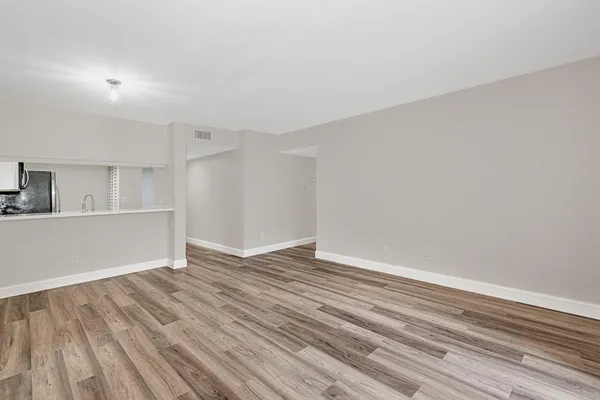 a view of empty room with wooden floor
