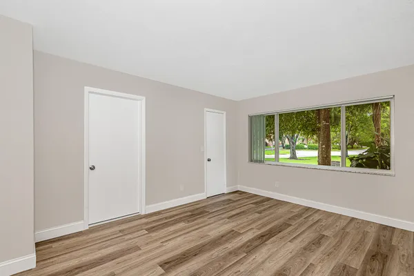 a view of a room with wooden floor and window