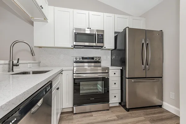 a kitchen with a refrigerator sink and cabinets