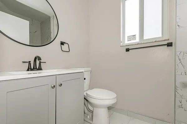 a bathroom with a toilet sink and mirror