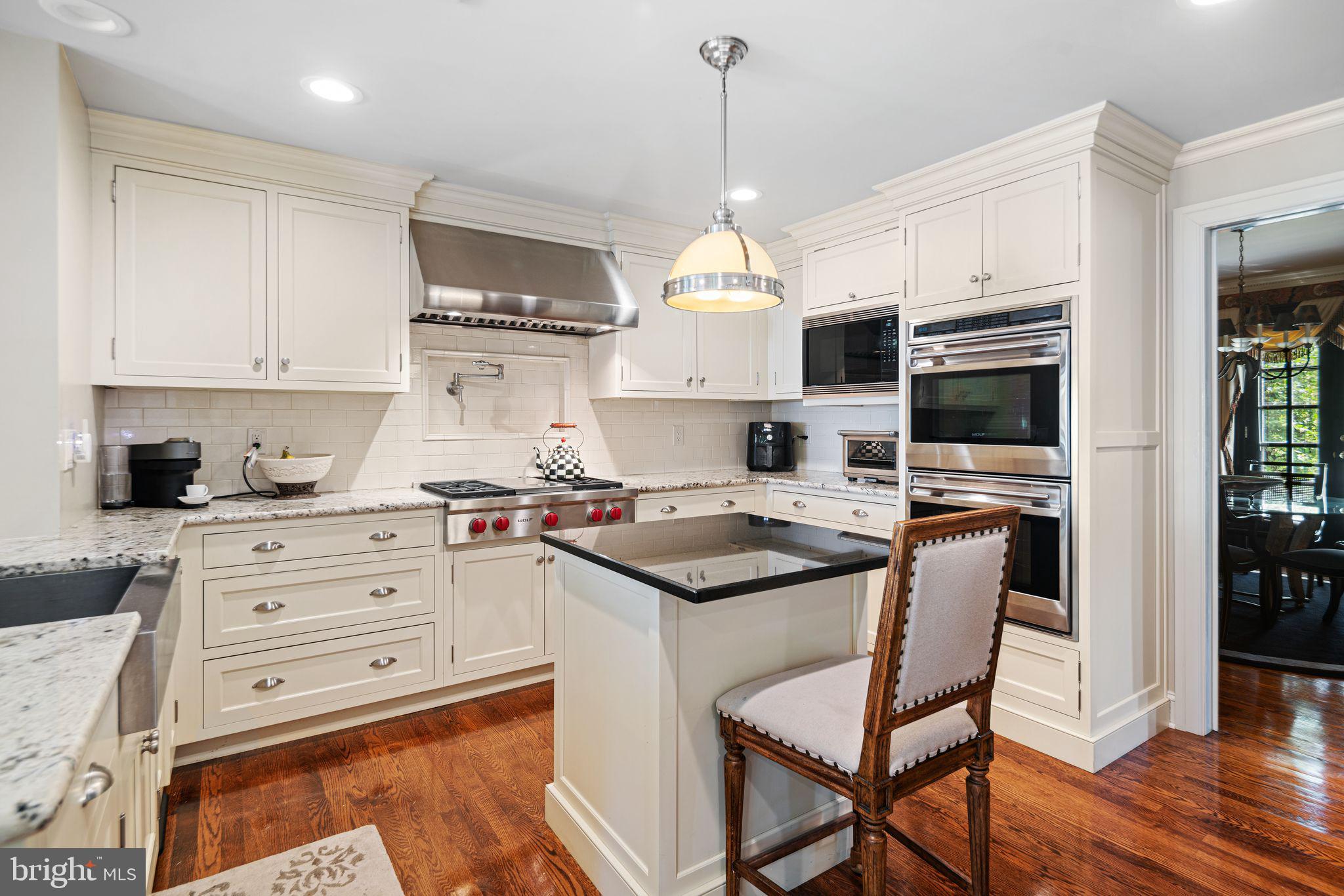 902 Warwick Road Haddonfield, NJ 08033 - Photo 9 of 43 a kitchen with stainless steel appliances granite countertop a stove a sink a microwave a refrigerator and white cabinets with wooden floor