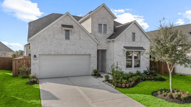 a front view of a house with a garden and plants