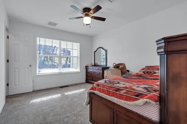 a bedroom with a bed and a ceiling fan
