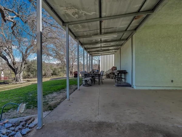a view of a patio with table and chairs and a barbeque