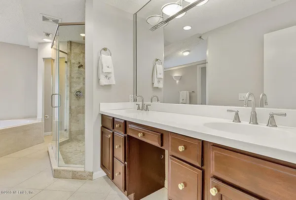 a bathroom with a granite countertop sink a shower and a mirror