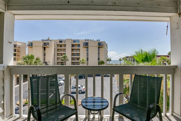 a balcony with table and chairs