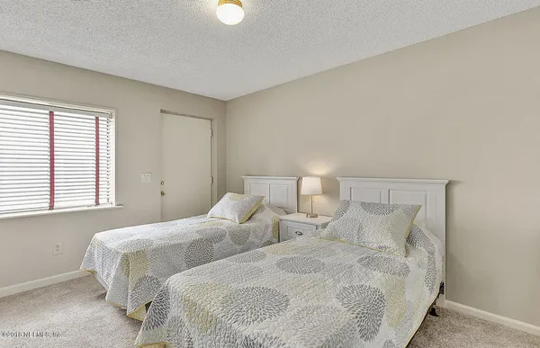 a bedroom with two beds and a window