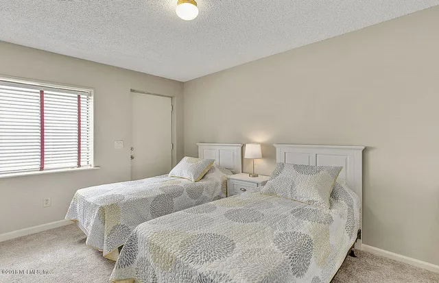 a bedroom with two beds and a window