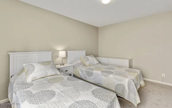 a large bed sitting in a bedroom next to a lamp