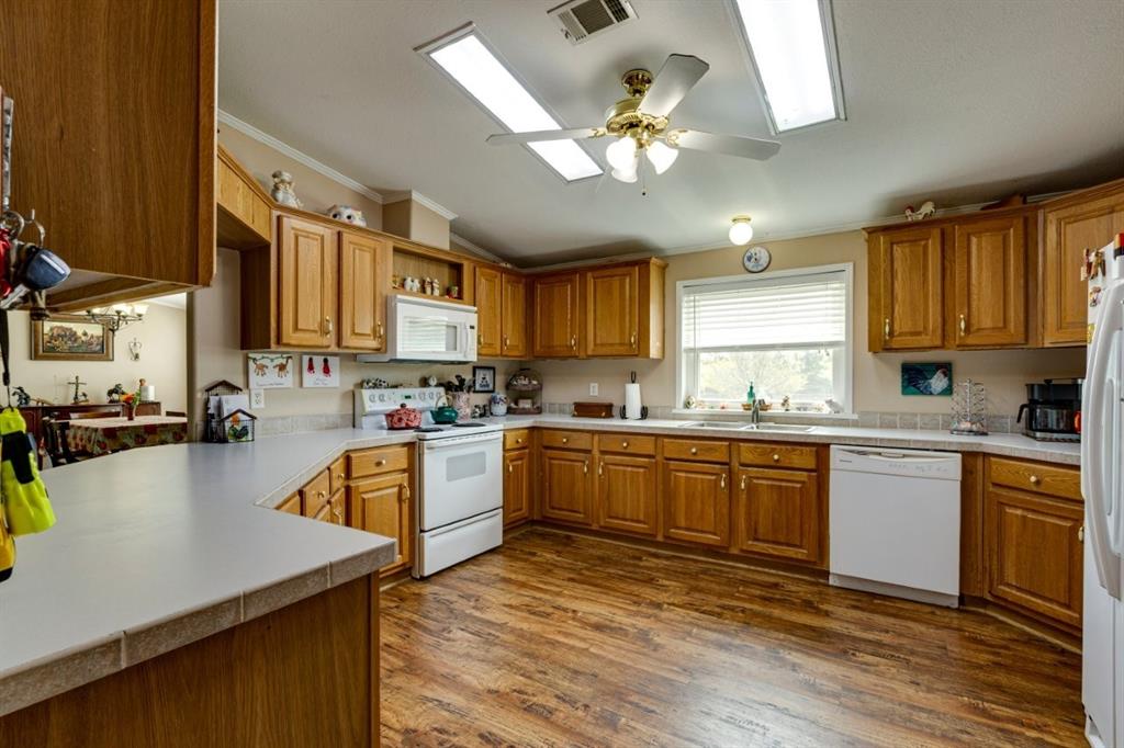 4880 Whitehead Road Midlothian, TX 76065 - Photo 11 of 36 a kitchen with stainless steel appliances granite countertop a sink dishwasher a stove top oven a refrigerator with island and chairs with wooden floor