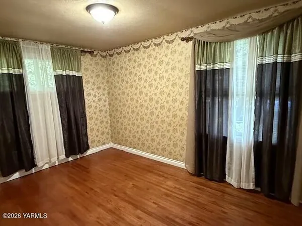 an empty room with wooden floor and a window