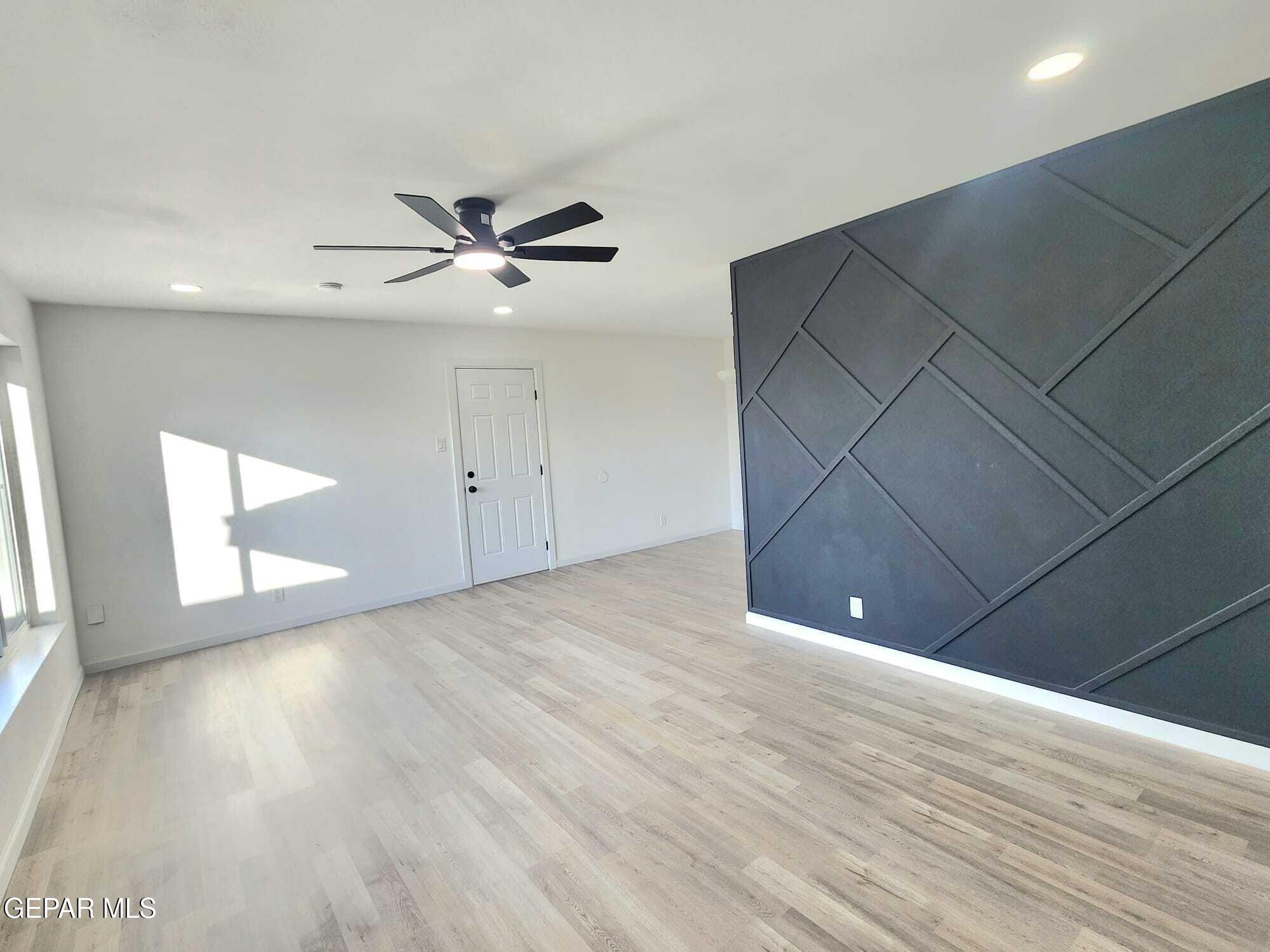 5845 Threadgill Avenue El Paso, TX 79924 - Photo 20 of 50 a view of a livingroom with a ceiling fan and wooden floor