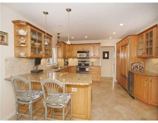 2 Wilson Ridge Road Darien, CT 06820 - Photo 10 of 20 a open kitchen with stainless steel appliances granite countertop a stove a refrigerator a kitchen island a dining table and chairs with wooden floor