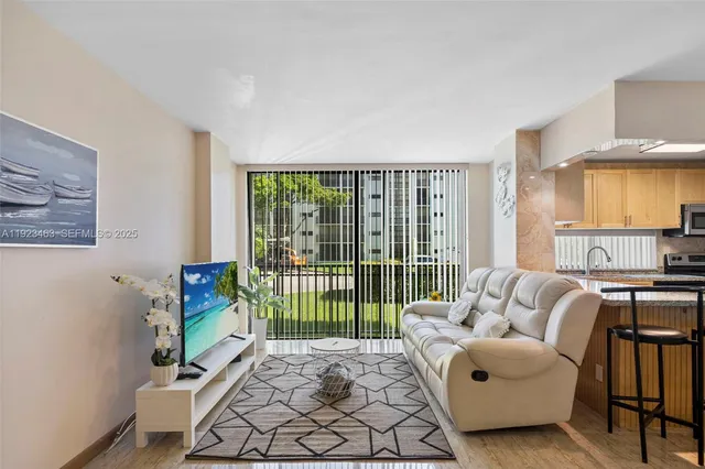 a living room with furniture floor to ceiling window and a rug