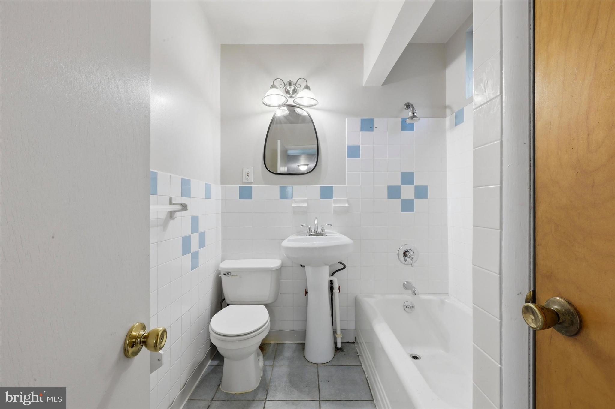 2044 North 63rd Street Philadelphia, PA 19151 - Photo 13 of 26 a bathroom with a toilet sink vanity tub and shower