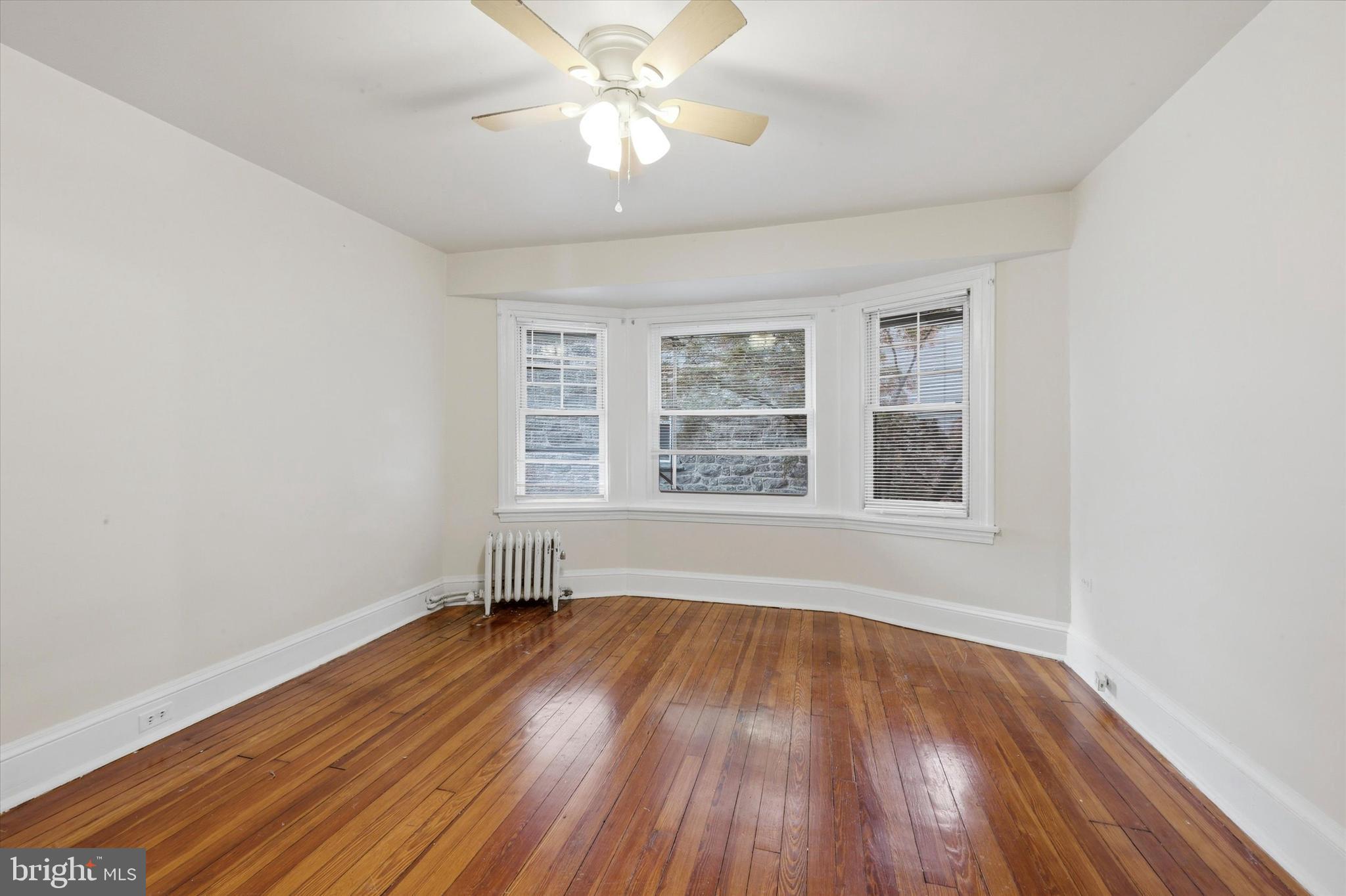 2044 North 63rd Street Philadelphia, PA 19151 - Photo 21 of 26 an empty room with wooden floor chandelier fan and windows