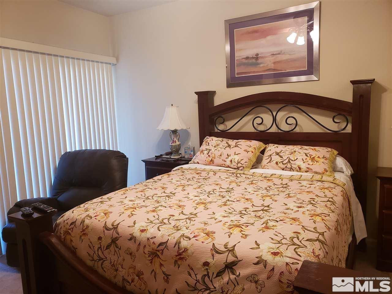 1325 South Meadows Parkway, Unit 311 Reno, NV 89521 - Photo 16 of 37 a bed sitting in a bedroom next to a window