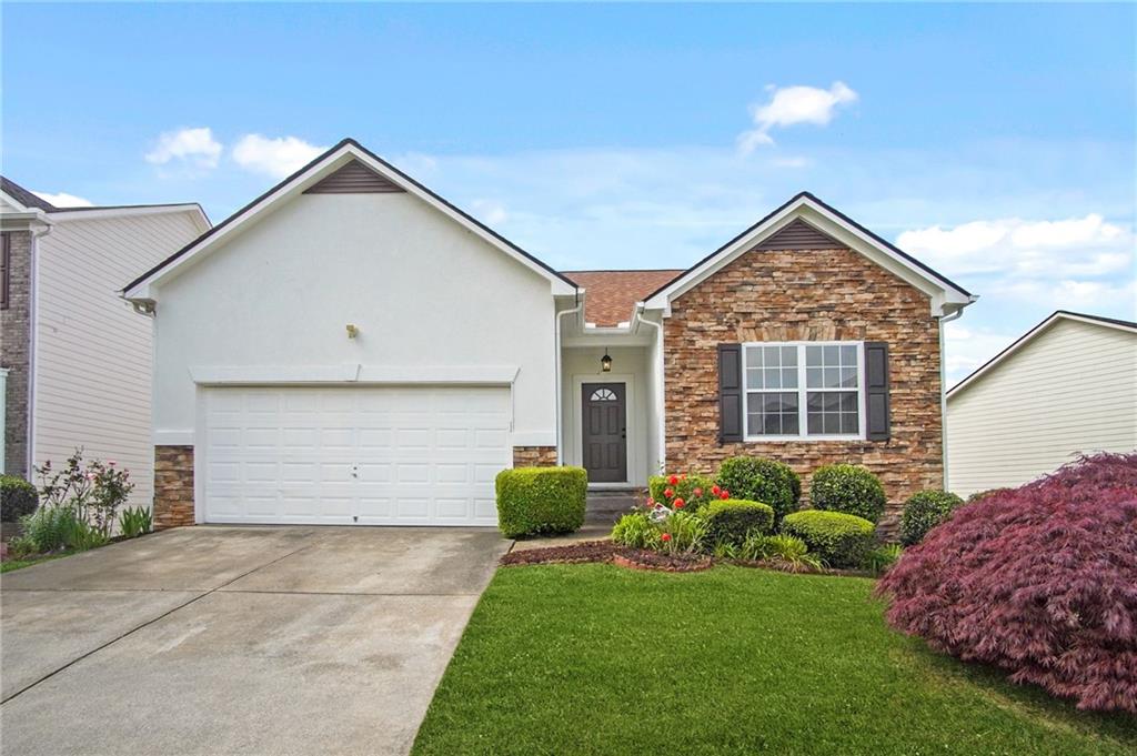 a front view of a house with a garden and plants
