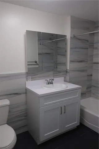 a bathroom with a sink toilet vanity and tub
