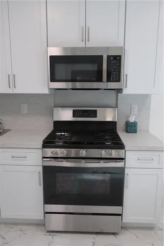 a stove top oven sitting inside of a kitchen