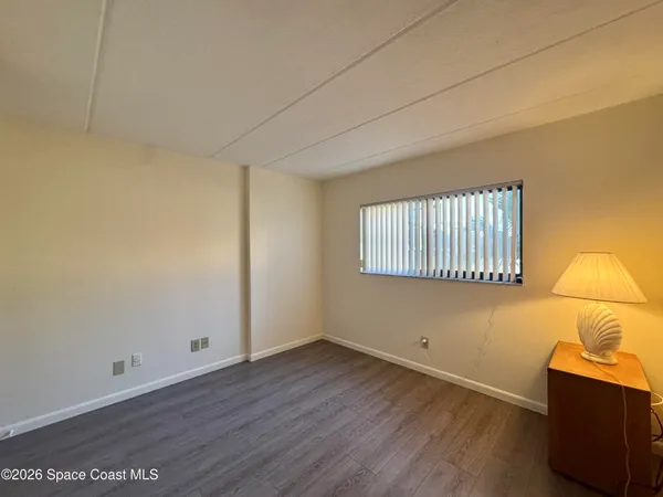 a view of a room with wooden floor and a window