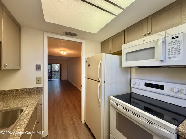 a kitchen with a refrigerator and a stove top oven