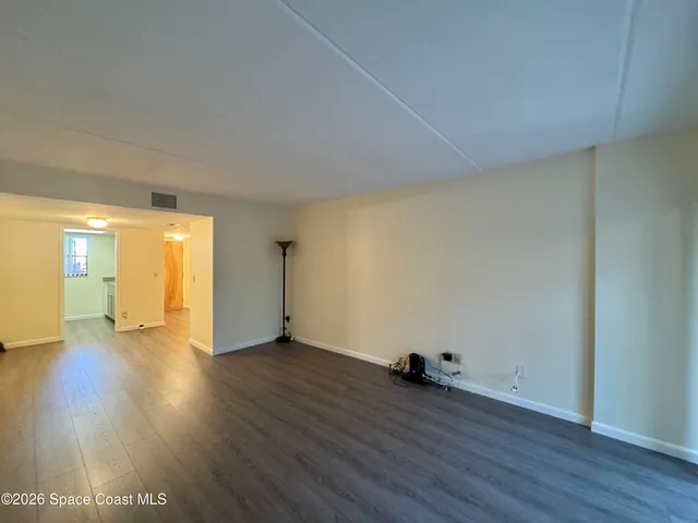 a view of a room with wooden floor and window