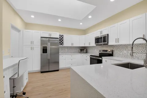 a kitchen with granite countertop white cabinets and white appliances