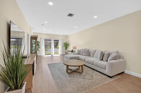 a large kitchen with stainless steel appliances a refrigerator a sink dishwasher and a stove with wooden floor