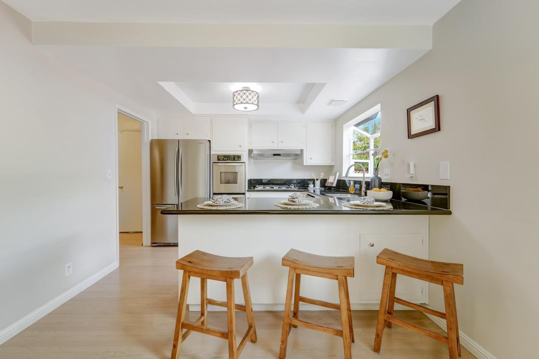 637 Laird Lane Lafayette, CA 94549 - Photo 13 of 44 a kitchen with stainless steel appliances granite countertop a dining table chairs and a refrigerator